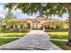 Attractive home features a paver driveway, a meticulously maintained lawn, lush landscaping, and a well-lit two-car garage at 9178 Panzani Pl, Windermere, FL 34786