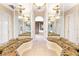 Mirrored hallway leading to a bathroom with tiled floor and chandelier at 9178 Panzani Pl, Windermere, FL 34786