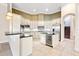 A well-appointed kitchen boasts white cabinets, granite countertops, stainless steel appliances, and tile flooring at 9178 Panzani Pl, Windermere, FL 34786