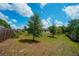 Large backyard featuring lush grass, beautiful trees, and a well-maintained fence at 936 Dandridge Dr, Deltona, FL 32725
