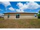 Rear view of the home, highlighting a sliding glass door and a spacious backyard at 936 Dandridge Dr, Deltona, FL 32725