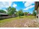 The grassy backyard features a charming fence and mature trees, offering shade and privacy at 936 Dandridge Dr, Deltona, FL 32725