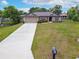 Charming one-story home with a well-maintained lawn and a long driveway leading to an attached two-car garage at 936 Dandridge Dr, Deltona, FL 32725