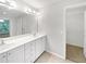 Bathroom with double sinks, white cabinets and a view into the bedroom and walk in closet at 9665 Se 125Th Ln, Summerfield, FL 34491