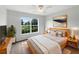 Cozy bedroom with a ceiling fan and a large window, providing ample natural light and a peaceful retreat at 9665 Se 125Th Ln, Summerfield, FL 34491
