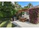 Outdoor patio with a grill, dining set, and bougainvillea-covered pergola in a landscaped backyard at 1020 Mayfield Ave, Winter Park, FL 32789