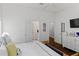 Bright bedroom with white walls and wood floors, featuring a TV, dresser and interior doorways at 1020 Mayfield Ave, Winter Park, FL 32789