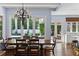 Elegant dining room with hardwood floors, decorative chandelier, and large windows overlooking the landscaped backyard at 1020 Mayfield Ave, Winter Park, FL 32789