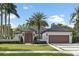 Stunning home featuring manicured lawns, a symmetrical facade, and a welcoming driveway framed by lush landscaping at 1020 Mayfield Ave, Winter Park, FL 32789