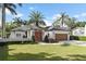 Beautiful single-story home with a well-manicured lawn, palm trees, and a charming wooden garage door at 1020 Mayfield Ave, Winter Park, FL 32789