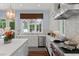Modern kitchen with a center island, stainless steel appliances, and a view of the outdoor greenery at 1020 Mayfield Ave, Winter Park, FL 32789
