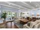 Open-concept living room with exposed beam ceilings, hardwood floors, and seamless indoor-outdoor flow to the pool at 1020 Mayfield Ave, Winter Park, FL 32789