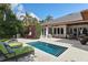 Backyard pool area with patio, seating, landscaping, and outdoor kitchen area at 1020 Mayfield Ave, Winter Park, FL 32789