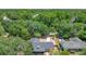 Aerial view of home with a driveway leading up to the house nestled among mature trees at 1025 Winter Springs Blvd, Winter Springs, FL 32708