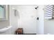 Close up of bright bathroom with white tile, walk-in shower, and a wooden bench at 1025 Winter Springs Blvd, Winter Springs, FL 32708