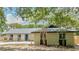 Charming one-story home with a blue front door, landscaped yard, and mature trees creating a welcoming curb appeal at 1025 Winter Springs Blvd, Winter Springs, FL 32708