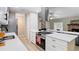 Open kitchen with stainless steel hood, quartz countertops, and view of the living area at 1025 Winter Springs Blvd, Winter Springs, FL 32708