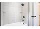 Modern bathroom with a shower over tub, with matte black shower head, faucet and white tile at 1025 Winter Springs Blvd, Winter Springs, FL 32708