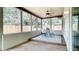 Bright sunroom featuring a ceiling fan, neutral walls, and ample windows for natural light and outdoor views at 1025 Winter Springs Blvd, Winter Springs, FL 32708