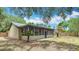 Backyard featuring a newly updated screened-in porch and mature landscaping at 1025 Winter Springs Blvd, Winter Springs, FL 32708
