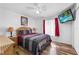 Cozy bedroom boasts wood floors, a ceiling fan, and a mounted television at 1065 Jason Ridge Ct, Kissimmee, FL 34747