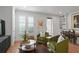 Bright living room featuring hardwood floors, white walls, plantation shutters, and stylish green armchairs at 1068 Lake Baldwin Ln, Orlando, FL 32814