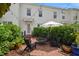 Cozy brick patio with comfortable seating, lush greenery, and an umbrella for shaded outdoor relaxation at 1068 Lake Baldwin Ln, Orlando, FL 32814