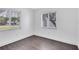 Bright bedroom featuring hardwood floors, two windows with blinds, and white walls at 1140 S Orlando Ave # E-1, Maitland, FL 32751