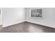 Bedroom featuring new hardwood floors, white walls, and a window with blinds at 1140 S Orlando Ave # E-1, Maitland, FL 32751