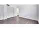 Bedroom showcasing new hardwood floors, white walls, and a large closet with bi-fold doors at 1140 S Orlando Ave # E-1, Maitland, FL 32751