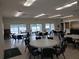 Large community room with tables and chairs, featuring expansive windows with lake views and an inviting atmosphere at 1140 S Orlando Ave # E-1, Maitland, FL 32751