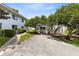 Paved driveway leading to a well-maintained condo building with mature trees and landscaping at 1140 S Orlando Ave # E-1, Maitland, FL 32751