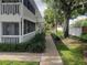 Exterior view of the property featuring white railings, stairs, landscaping, and a sidewalk at 1140 S Orlando Ave # E-1, Maitland, FL 32751