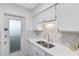 Updated kitchen with white cabinetry, modern countertops, and stainless-steel sink at 1140 S Orlando Ave # E-1, Maitland, FL 32751