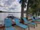 Relaxing lake view with lounge chairs and palm trees, perfect for enjoying the waterfront ambiance at 1140 S Orlando Ave # E-1, Maitland, FL 32751
