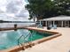 A serene swimming pool is surrounded by lounge chairs, with a view of the lake and clear blue skies at 1140 S Orlando Ave # E-1, Maitland, FL 32751