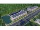 Expansive aerial view showcases community buildings, ample parking, and a picturesque pond surrounded by lush trees at 1250 Water Maple Dr, Oakland, FL 34787