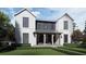 Striking two-story home featuring light siding and dark accents, with a covered front porch and manicured landscaping at 1250 Water Maple Dr, Oakland, FL 34787