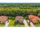 Aerial view of a charming home with lush landscaping, tile roof, and a paved driveway, surrounded by trees at 132 Rosa Bella Vw, Debary, FL 32713