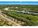 Aerial view of a neighborhood featuring well-maintained streets, lush green spaces, and homes with tile roofs at 132 Rosa Bella Vw, Debary, FL 32713