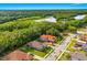 Aerial perspective of neighborhood homes with tile roofs adjacent to a verdant nature preserve with a lake at 132 Rosa Bella Vw, Debary, FL 32713