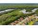 Scenic aerial view showcasing homes nestled near a river and lush green spaces in a well-maintained neighborhood at 132 Rosa Bella Vw, Debary, FL 32713