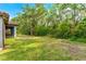 A lush green backyard adjacent to a screen lanai, blending natural foliage with residential charm at 132 Rosa Bella Vw, Debary, FL 32713