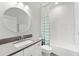Clean bathroom with a modern vanity, a round mirror, and a tiled tub/shower combo at 132 Rosa Bella Vw, Debary, FL 32713