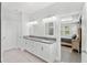 Bright bathroom with double sinks, gray counters, white cabinets and mirrors and an adjoining bedroom at 132 Rosa Bella Vw, Debary, FL 32713