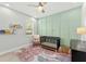 Charming Bedroom with a modern crib, green accent wall, and floral rug at 132 Rosa Bella Vw, Debary, FL 32713