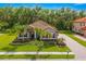 Stunning exterior showcasing manicured lawn, stone accents, lush landscaping, and a brick driveway at 132 Rosa Bella Vw, Debary, FL 32713