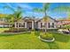 Charming home with a well-manicured lawn, mature palm trees, and decorative landscaping at 132 Rosa Bella Vw, Debary, FL 32713