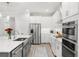 Modern kitchen with stainless appliances, a large sink, and stylish white cabinetry at 132 Rosa Bella Vw, Debary, FL 32713