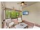 Inviting screened lanai with comfortable seating, ceiling fans, and a view of the natural surroundings at 132 Rosa Bella Vw, Debary, FL 32713